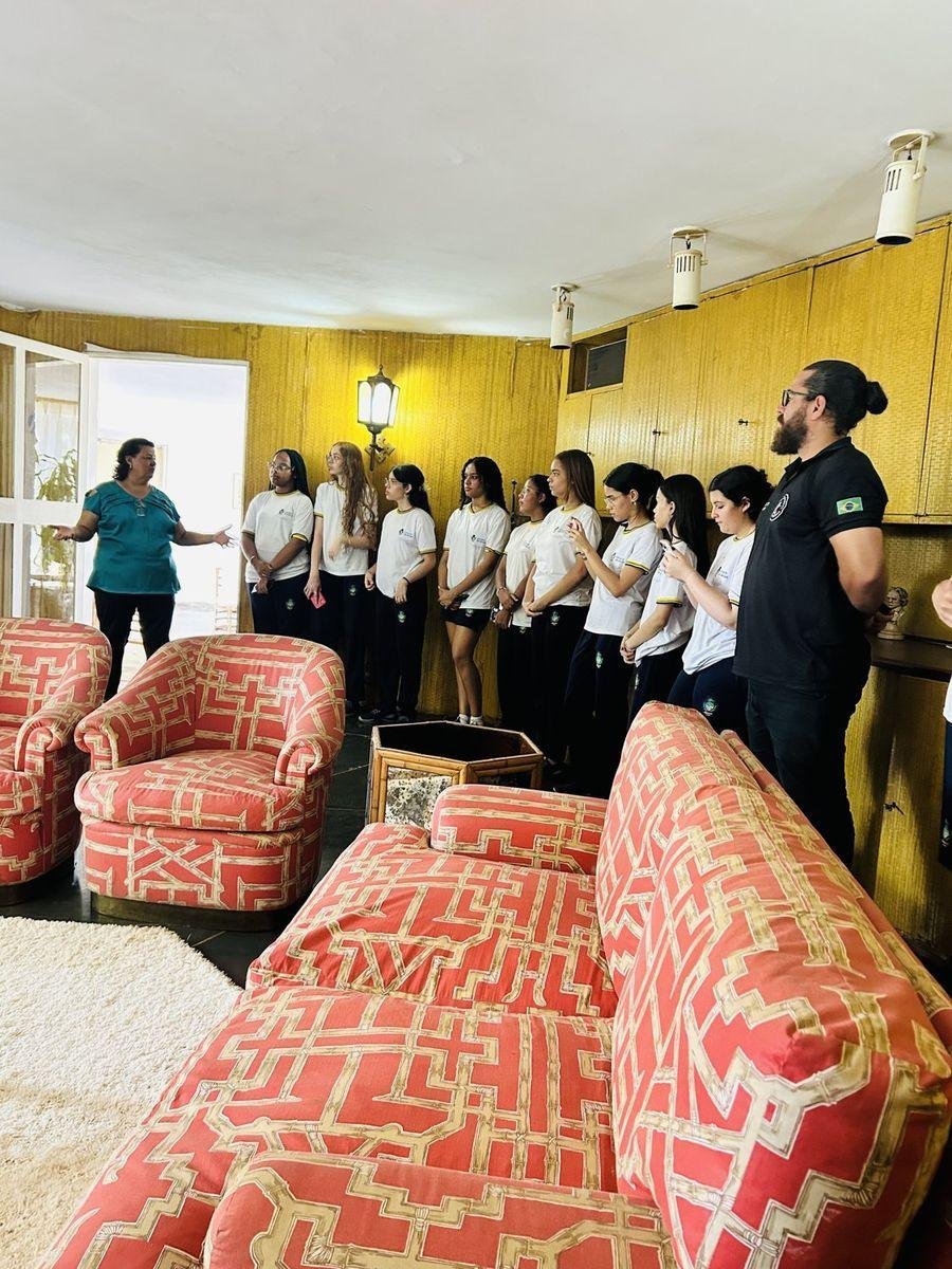 Estudantes em visita guiada na sala da casa