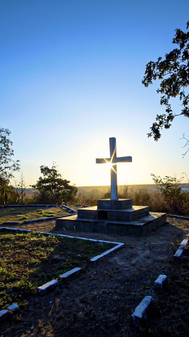 Cruz contra o sol poente no cerrado